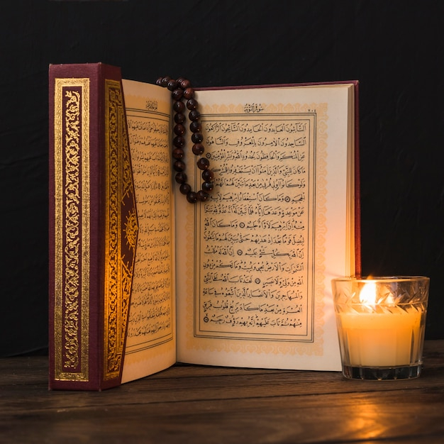 Close-up glass with candle and Quran