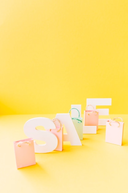 White sale word with small pink shopping bag on yellow background