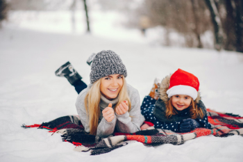 Little girl with mother playing in a winter park Free Photo