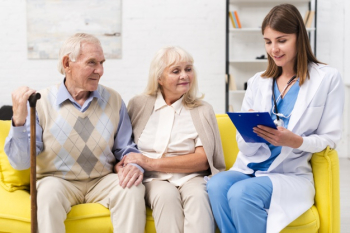 Nurse sitting with old man and woman on sofa Free Photo