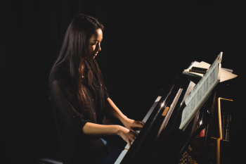 Female student playing piano Free Photo