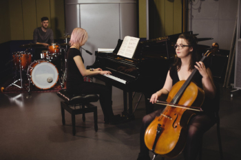 Group of students playing double bass, drum set and piano Free Photo