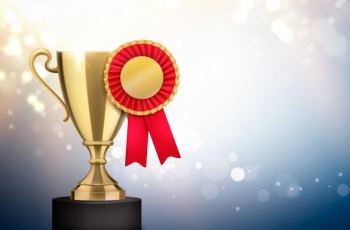 Winner gold trophy with red pleated badge rosette award realistic closeup composition blurry light Free Vector