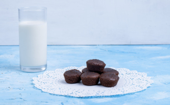 Side view of chocolate muffin served with a glass of milk on blue Free Photo