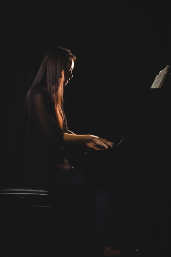 Female student playing piano Free Photo
