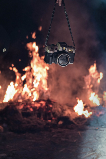 Person Holding Black and Grey Camera Near Fire