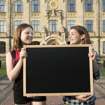 Medium shot highschool girls holding blackboard Free Photo