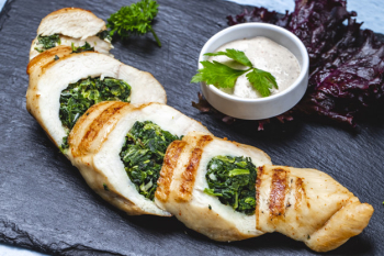 Side view chicken breast stuffed with spinach and sauce on the table Free Photo