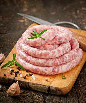 Fresh raw sausage on the old wooden background Free Photo