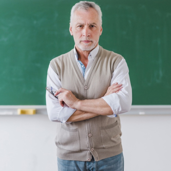 Senior male professor with arms crossed standing against chalkboard Free Photo