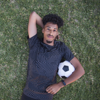 Relaxed sportsman lying on back during pause on lawn Free Photo