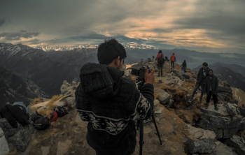 Man Taking Photo of Couple on Mountain Range