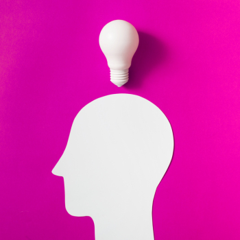 Light bulb over the cut out white human head on pink background