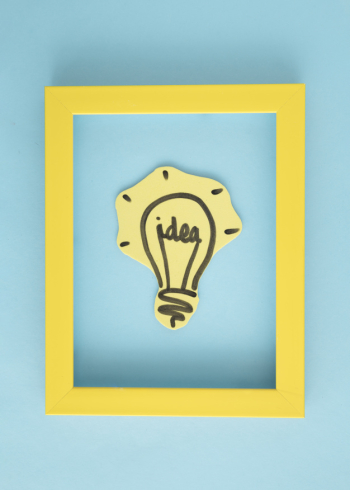 Idea light bulb inside the yellow frame on blue background