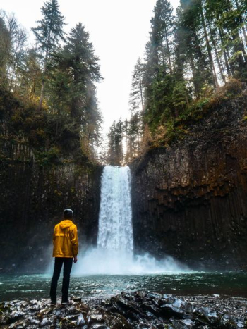 man standing in front of water falls