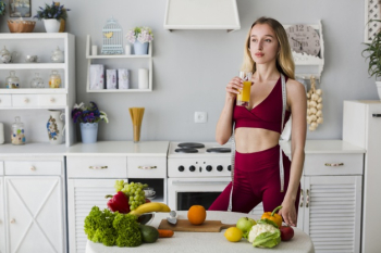 Diet concept with sporty woman in kitchen Free Photo