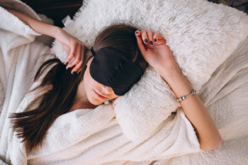 Woman in bed wearing sleeping mask
