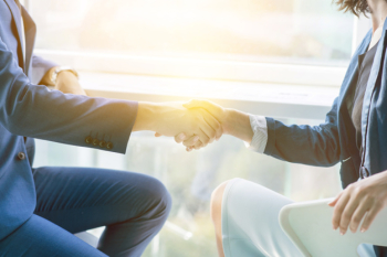 Sunlight falling on two businesspeople shaking hands