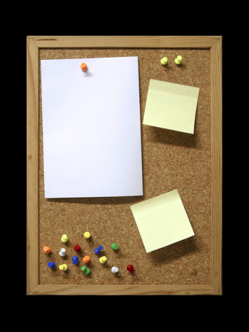 Corkboard with blank paper, pins and post-it.