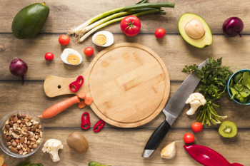Elevated view of fresh ingredients; egg; vegetables and chopping board with knife on table