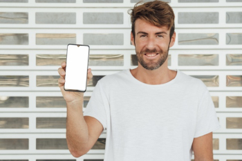 Happy man holding cellphone with mock-up Free Photo