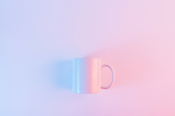 Pink coffee mug against pink background with copyspace for writing the text