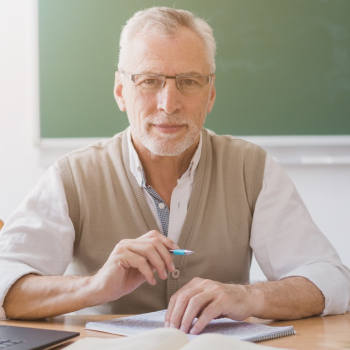 Senior professor holding pen at workplace in classroom Free Photo