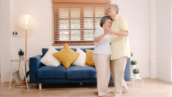 Asian elderly couple dancing together while listen to music in living room at home, sweet couple enjoy love moment while having fun when relaxed at home. Free Photo