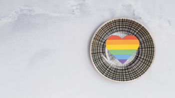 Multicolored lgbt heart on round plate on white background Free Photo