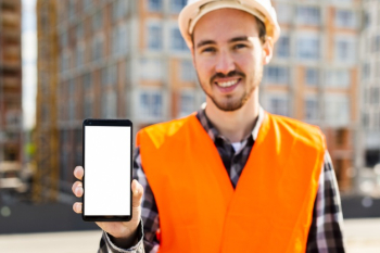 Medium shot portrait of construction engineer holding phone Free Photo