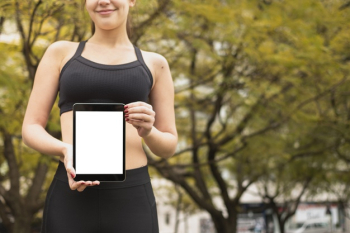 Fit athlete holding tablet with mock-up Free Photo