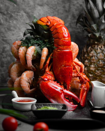 Lobster served with tiger prawns and sauces Free Photo