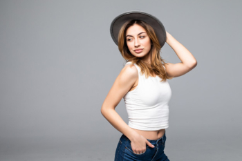 Portrait of a beautiful young girl in a hat isolated on gray wall Free Photo