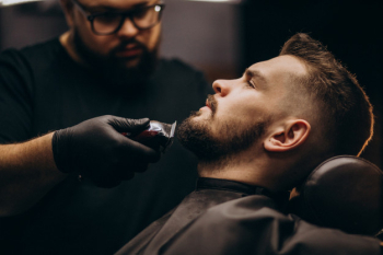 Handsome man cutting beard at a barber salon Free Photo