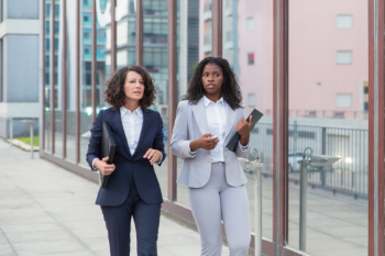 Multiethnic businesswomen with folders on street Free Photo