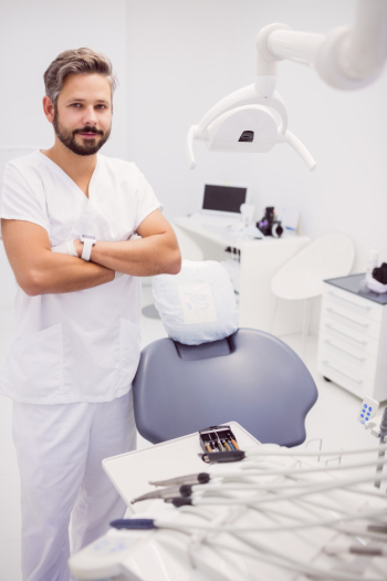 Dentist standing with his arms crossed Free Photo