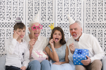 Portrait of a family holding party props and gift boxes sticking out tongue Free Photo