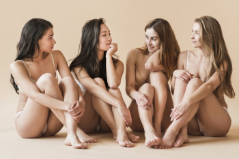 Group of young cheerful women in underwear sitting on floor Free Photo