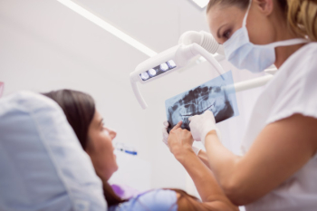 Dentist showing x-ray to the patient Free Photo