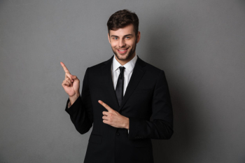 Young smiling man bearded businessman pointing with two finger upward, Free Photo