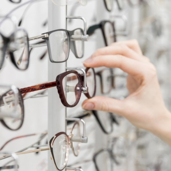 Close-up of woman's hand chooses glasses in optics shop Free Photo