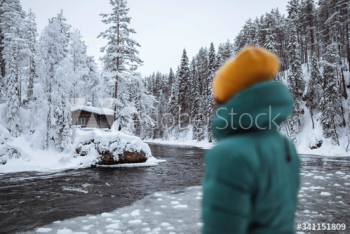 Woman at a frozen river in Lapland, Finland