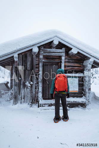 Woman standing in front of a snowy hut
