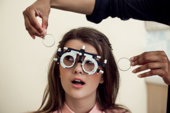 Eyecare and health concept. portrait of curious and entertained young european woman sitting on chair while eyecare specialist testing sight with phoropter, asking if she can see clearly Free Photo