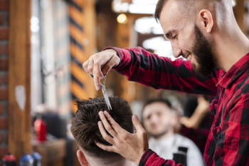 Barber using scissors to make a hairstyle Free Photo