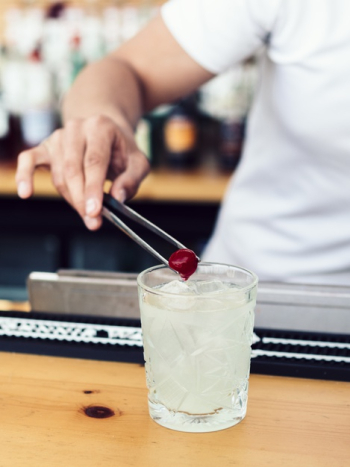 Male bartender adding cherry into drink Free Photo