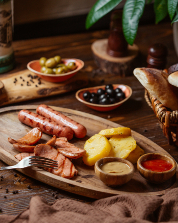 Grilled sausages plate with fried potatoes and mustard and ketchup Free Photo
