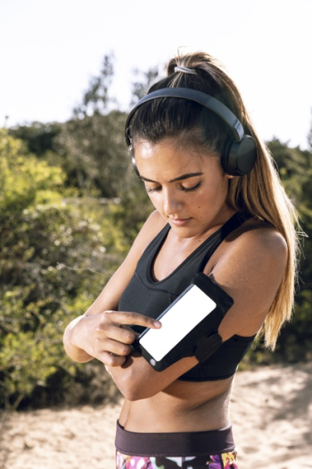 Woman at jogging putting music on her phone mock-up Free Photo