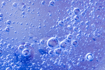 Abstract air bubbles in liquid on blue defocused background Free Photo