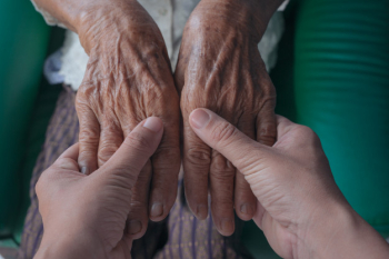 Young woman holding an elderly woman's hand. Free Photo